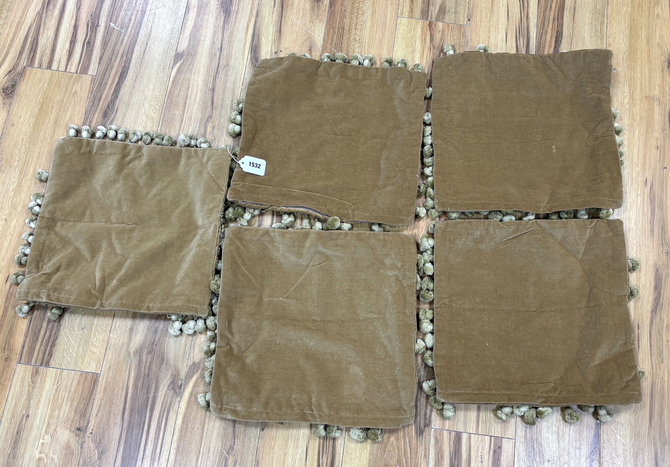 A set of five square woolwork cushion covers decorated with roses, and a bird, in greens, blues and pinks, edged with ornate tasseling and velvet backing, 37cm wide x 35cm high
